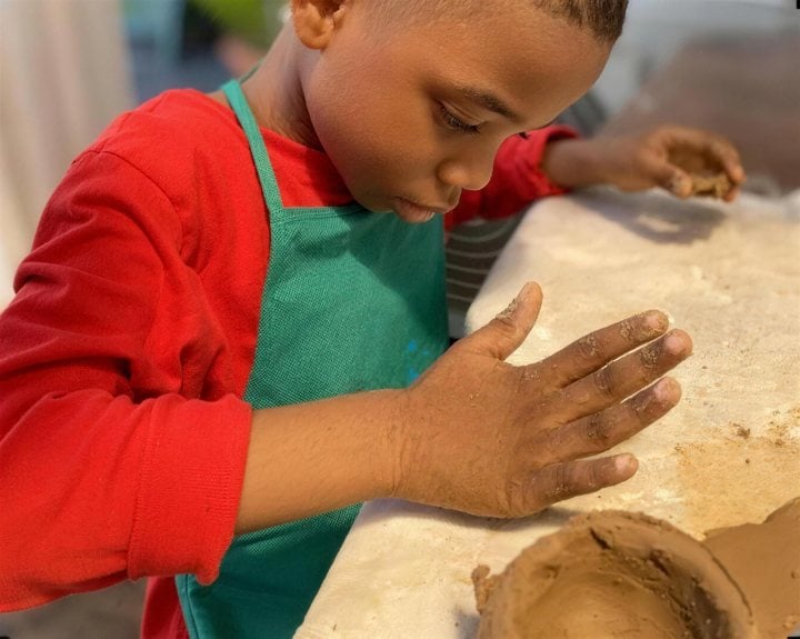 A boy shaping clay at a pottery class